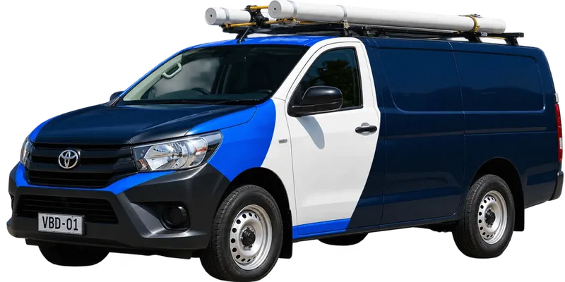 A licensed Burwood plumbing van loaded with pipe on the roof rack